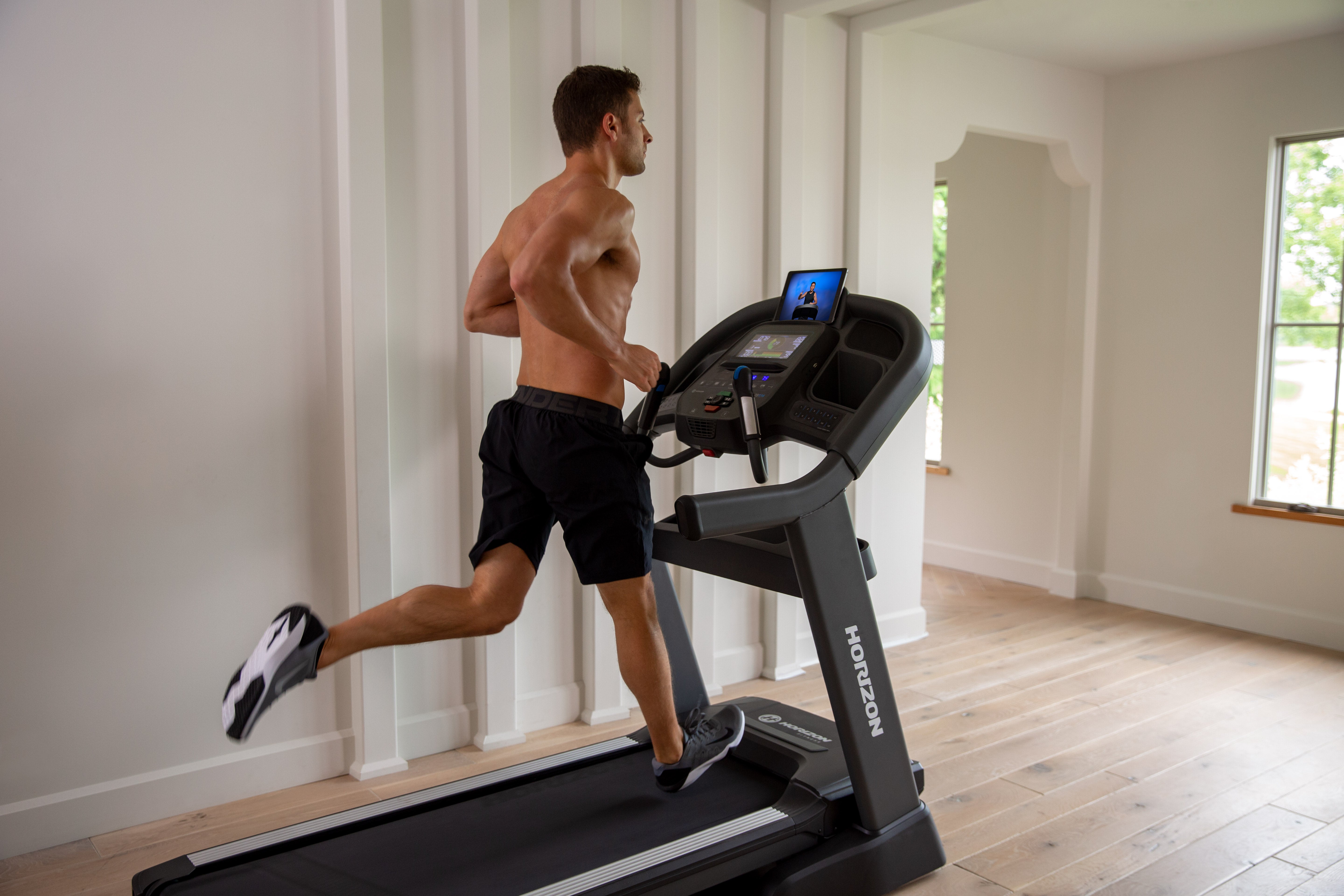 Man running on a treadmill in a home setting